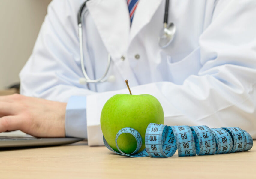 Diet healthy eating prevention concept, doctor apple and measuring tape