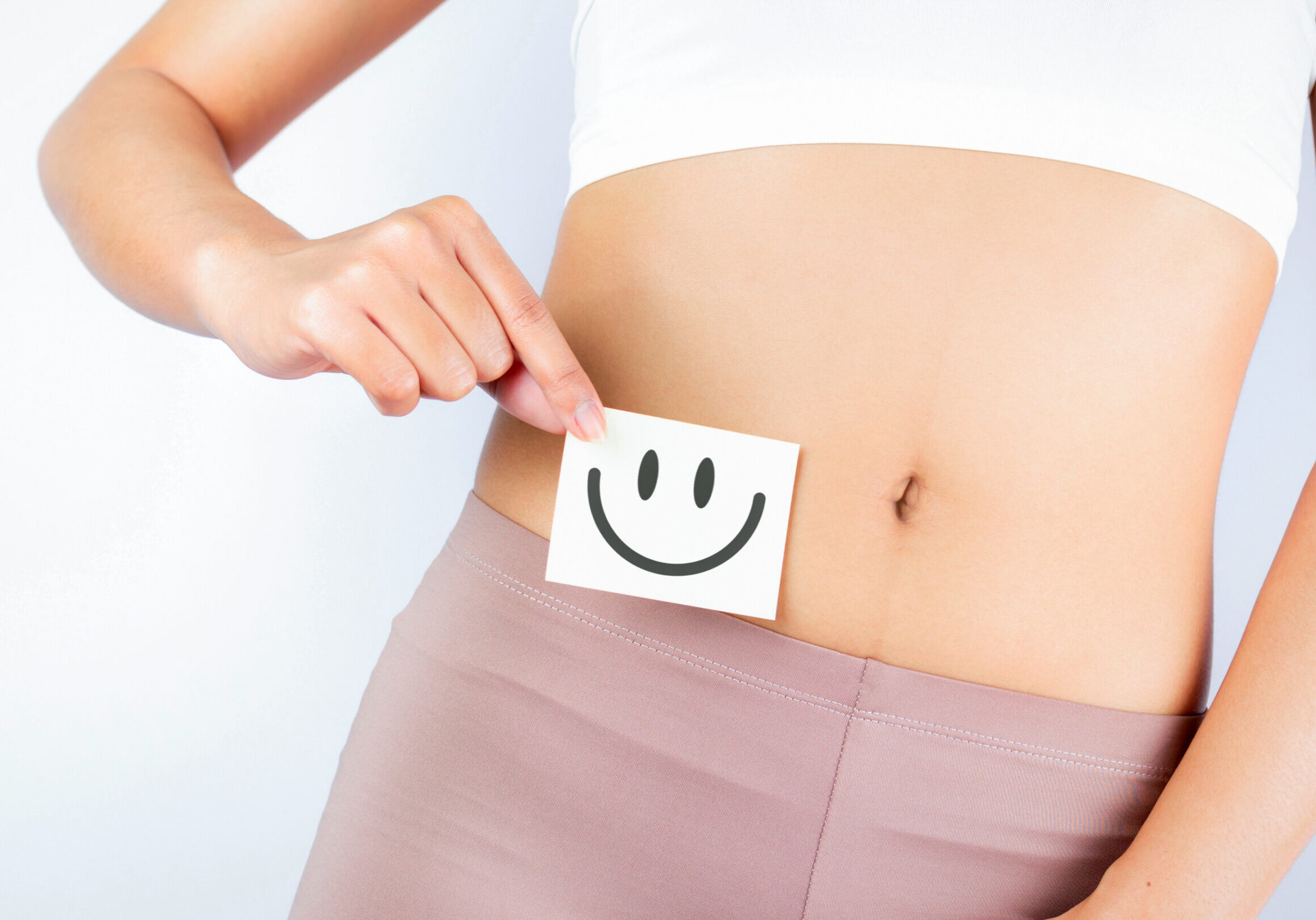 Women Stomach Health. Healthy Female With Beautiful Fit Slim Body  Holding White Card With Happy 
Smiley Face In Hands Good Digestion Concepts. High Resolution